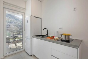 A modern kitchen with a built-in stove, a sink, and a refrigerator. - Seafront Villa Andrijana (Krsan)