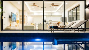 A modern interior with a pool, a dining area, and a kitchen. - Villa Close to Fisherman Village - KBR15 (Koh Samui)