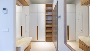 Une chambre moderne avec un placard intégré, un miroir et une table de chevet recouverte d’une housse blanche et moelleuse.