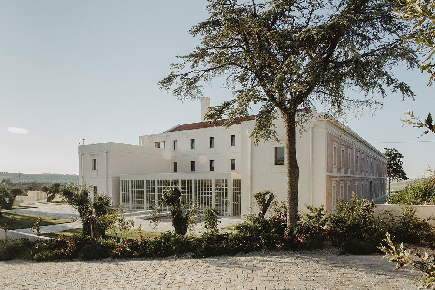 Un edificio moderno con fachada simétrica, ventanas amplias y una entrada central.