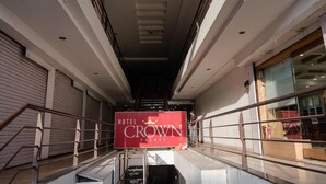 Entrada de un hotel con un cartel que dice "HOTEL CROWN PALACE".