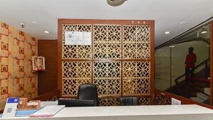 Zona de recepción con un separador de madera, un escritorio y una silla.