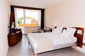 Een hotelkamer met een bed, een bureau, een stoel en uitzicht.
