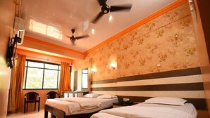 A hotel room with two beds, a desk, and a chair. - Hotel Shell Top  (Panaji)
