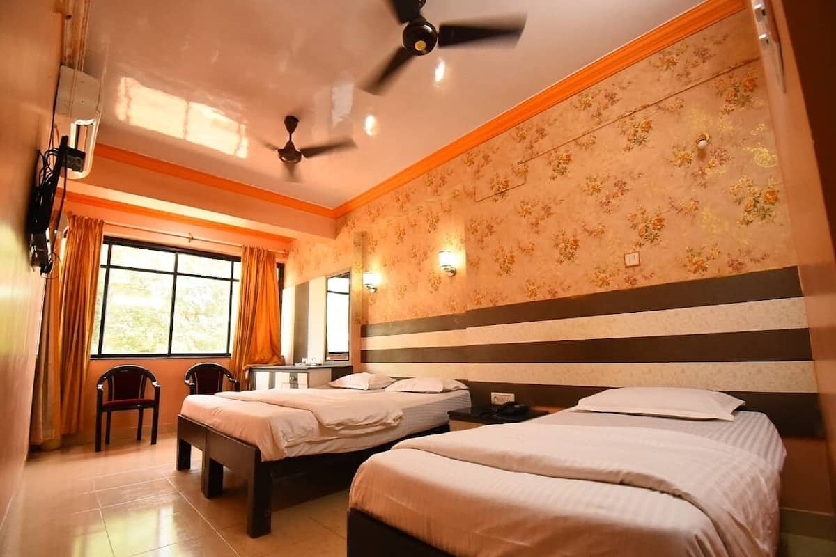 Habitación de hotel con dos camas, un escritorio y una silla.