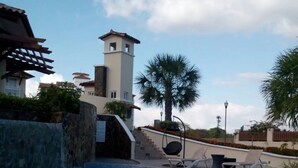 A swimming pool with a clear view of the surrounding buildings, including a tower structure and palm trees. - 🌤️Gulf Sea View Condo in San Carlos 4 bdr near Coronado, El Valle&🏄‍♂️schools (San Carlos)