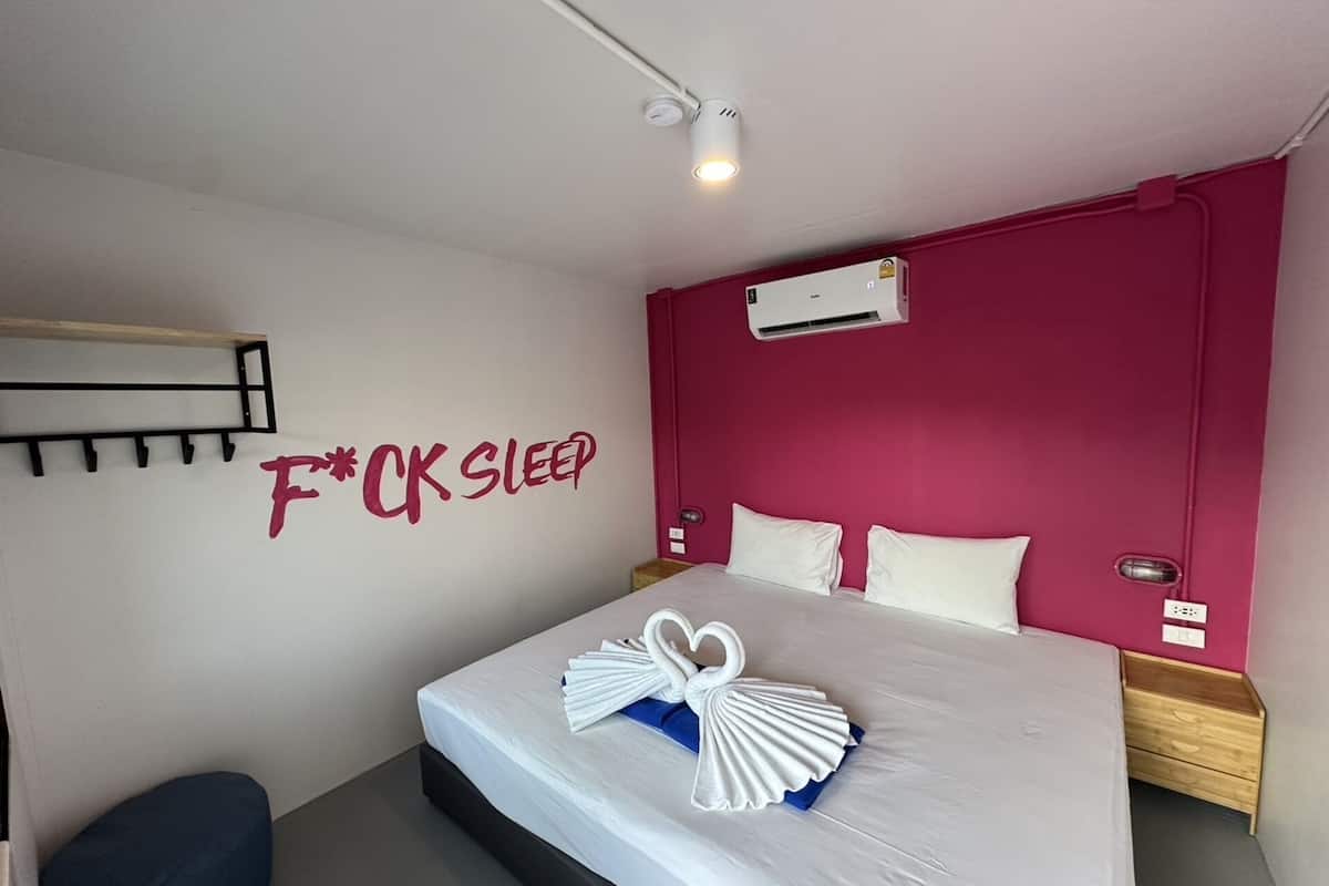 Habitación de hotel con cama, aire acondicionado de pared, lámpara de pared y estante de pared.