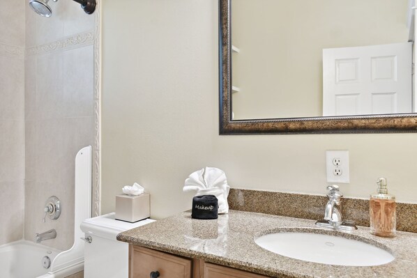 Une salle de bain avec un lavabo, un miroir et une douche.