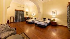 A hotel room with two beds, a desk, a chair, and a sofa. - Umed Bhawan Palace (Kota)
