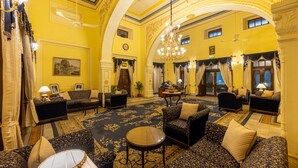 A grand lobby with ornate chandeliers, plush seating, and a large carpeted area. - Umed Bhawan Palace (Kota)