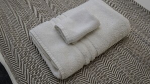 A folded white towel on a patterned carpet. - The Bradley Studio · Near Mystic, Casinos + USCGA (Groton)