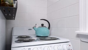 A white stove with four burners and a blue kettle on top. - The Pratt Studio · Near Mystic, Casinos + USCGA (Groton)