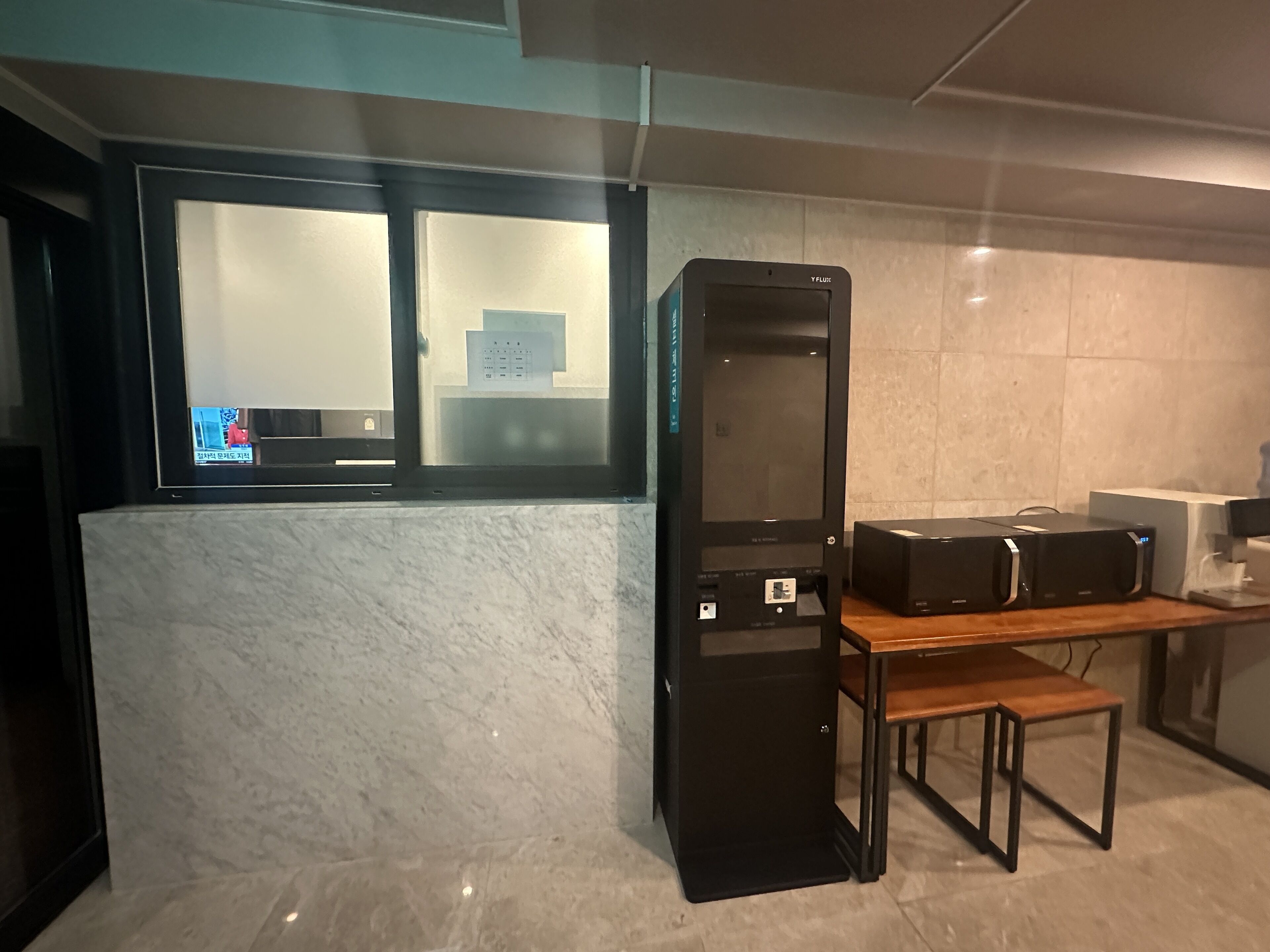 Una cocina moderna con encimera de mármol, un refrigerador negro y una mesa de madera.