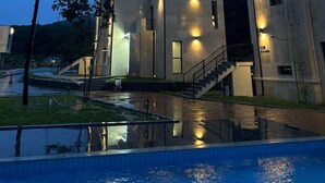 A modern building with a pool area, featuring a staircase and a small outdoor seating area. - The on tourist hotel (Seosan)