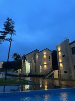 Un edificio moderno con zona de piscina, que incluye una escalera y un pequeño espacio al aire libre para sentarse.