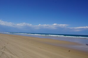 A beach with a clear sky and ocean waves.