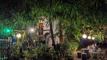 Un jardin intérieur agrémenté de plantes en pot et de luminaires suspendus.