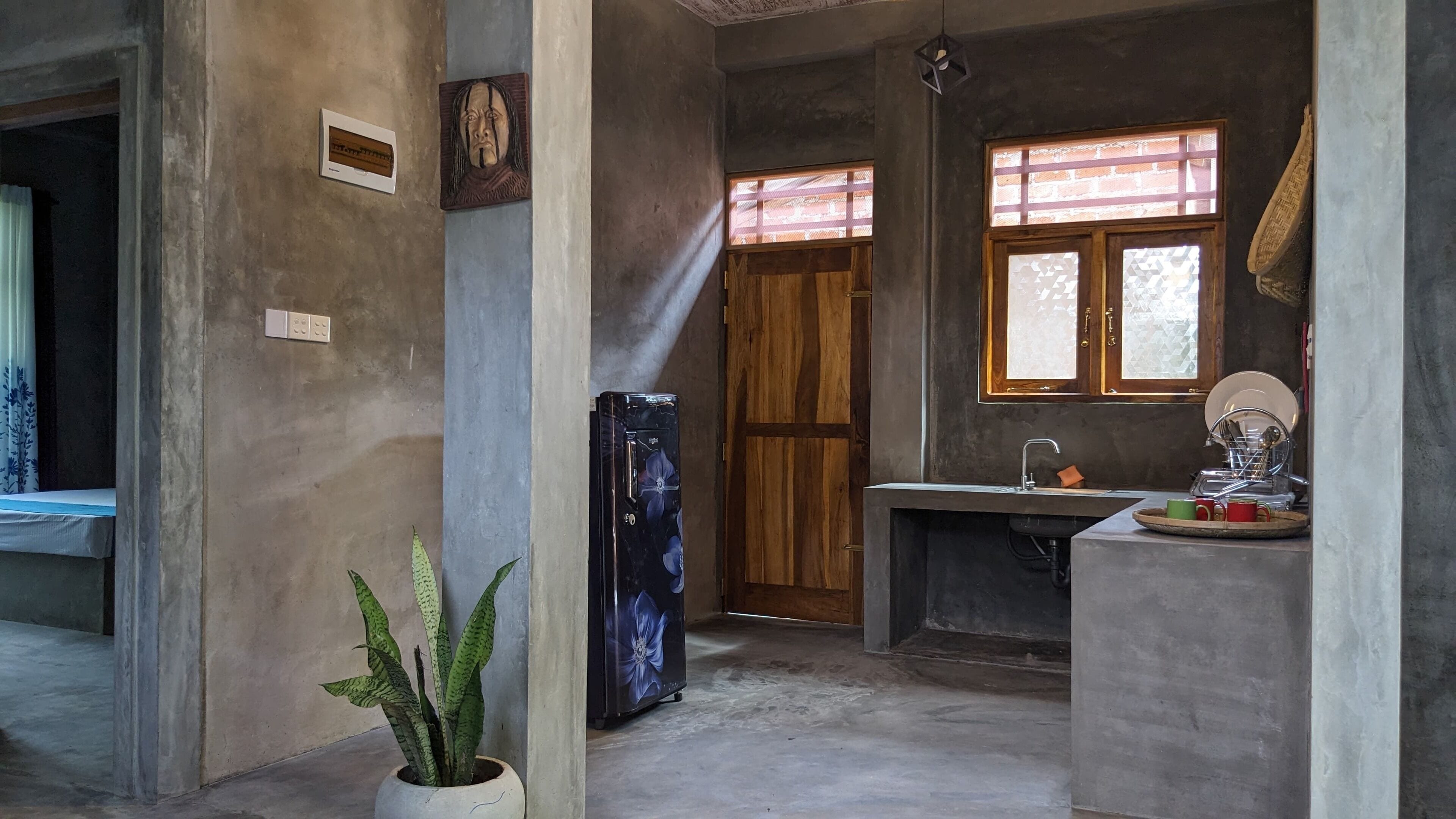 A kitchen with a wooden door, a sink, and a refrigerator.