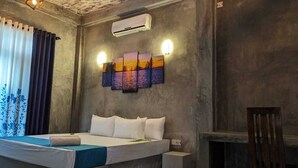 A bedroom with a bed, a nightstand, a wall-mounted air conditioner, and a set of wall sconces. - Soul Villas (Tangalle)