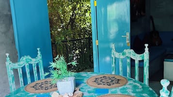 Un tavolo da pranzo dipinto di turchese con quattro tovagliette abbinate, circondato da sedie coordinate.