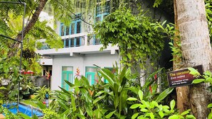A building surrounded by lush greenery, including a coconut tree sign indicating it is part of the palm tree family. - Soul Villas (Tangalle)