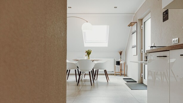 A modern kitchen with white cabinetry, a dining area with white chairs, and a large window providing natural light. - Wohnungtraveller Geislautern (Völklingen)