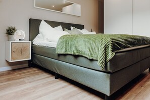 Restful retreat with a large bed, nightstand, and mirror.