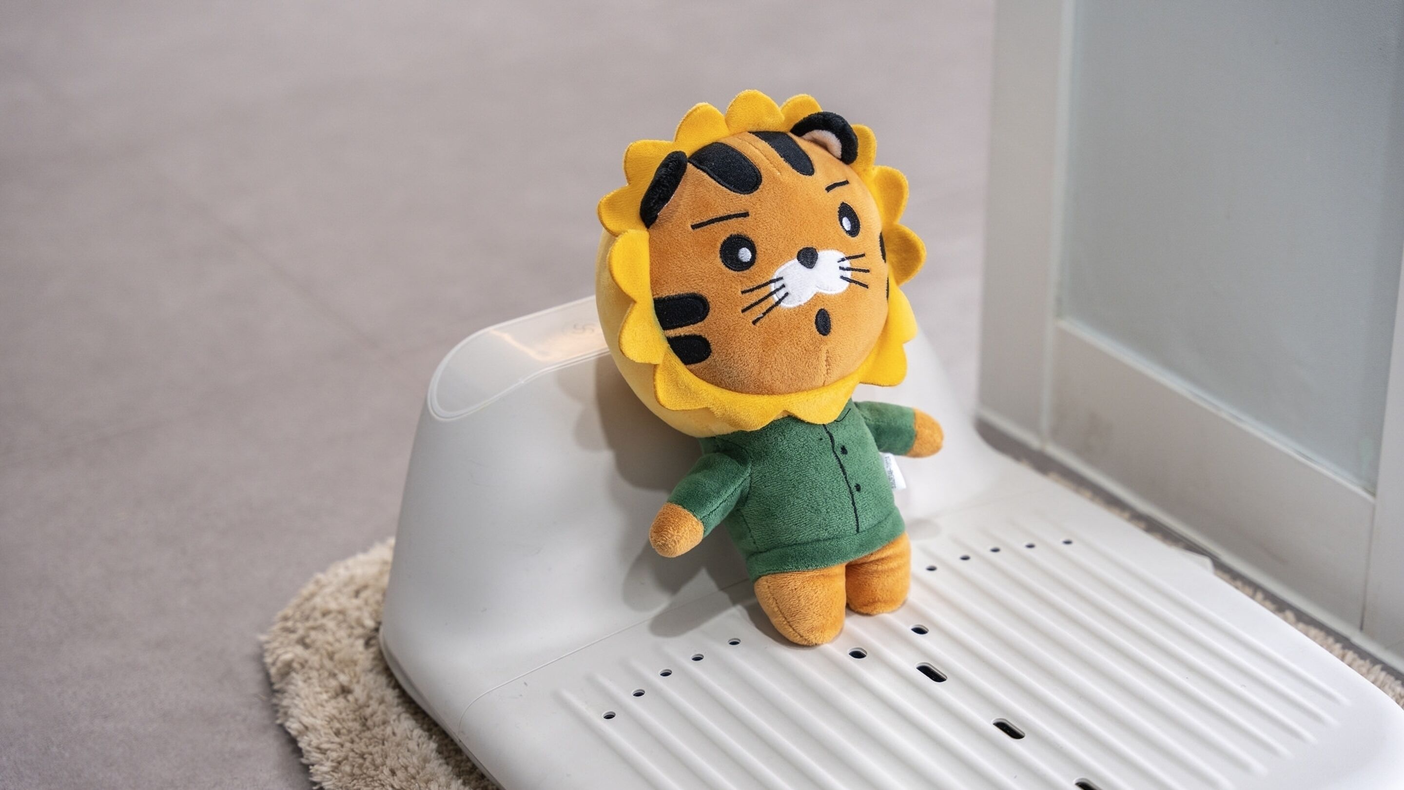A plush toy lion on a white mat.