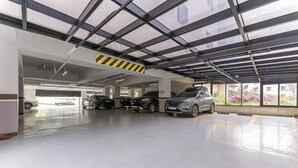 Un estacionamiento con varios niveles y varios coches aparcados.