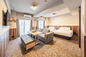 Une chambre d’hôtel avec un lit, un canapé, une table et un téléviseur.
