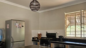 Cozinha moderna com uma ilha grande, eletrodomésticos de aço inoxidável e uma janela que traz luz natural.