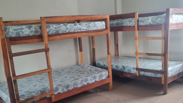 Beliches com colchões estampados em padrão floral em quarto com paredes lisas e chão de azulejos.