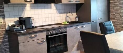 Een magnetron, een oven, een kookplaat, een vaatwasser