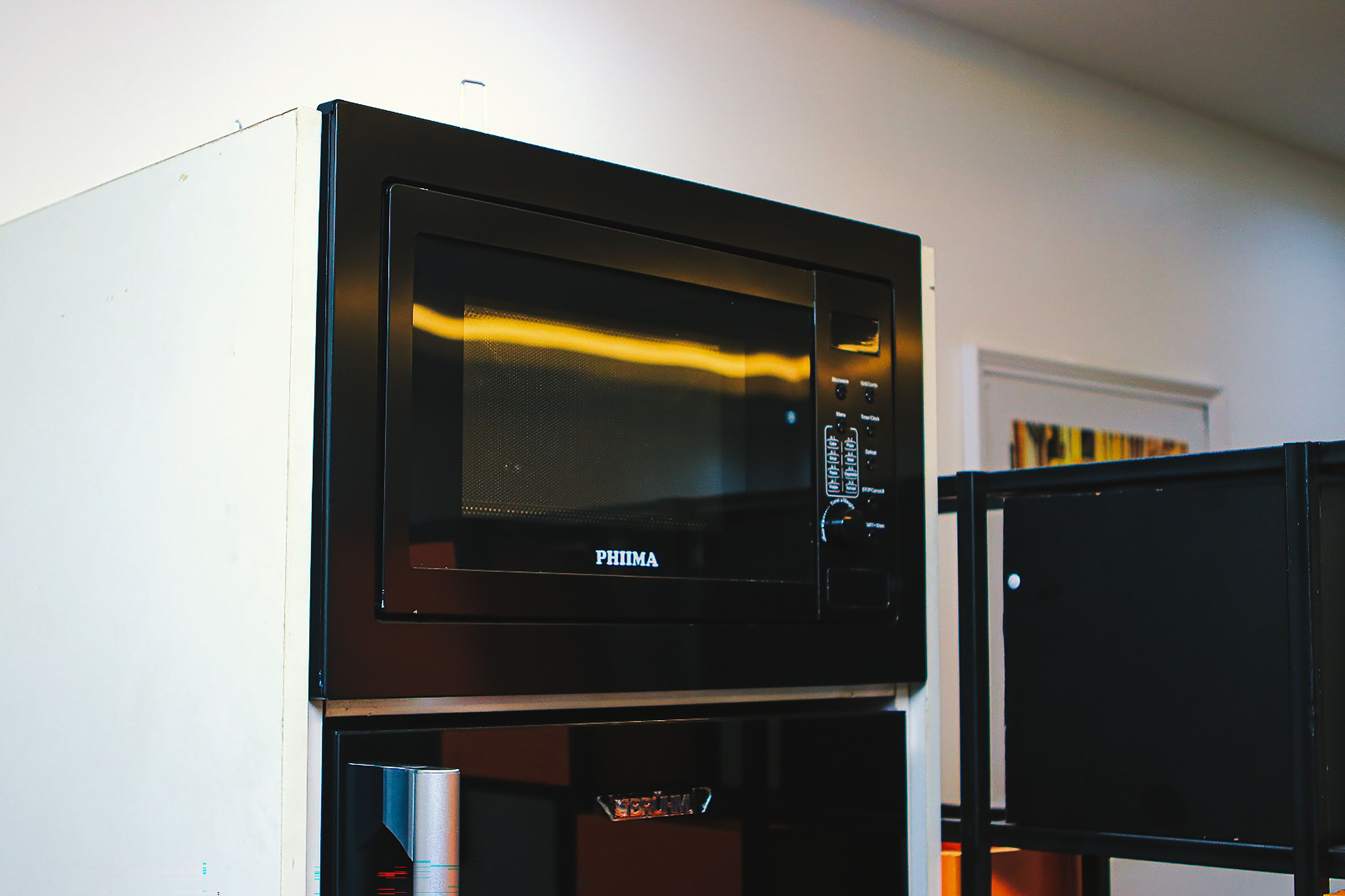 A PHIMA microwave oven with a digital display and control panel, placed on a kitchen counter.