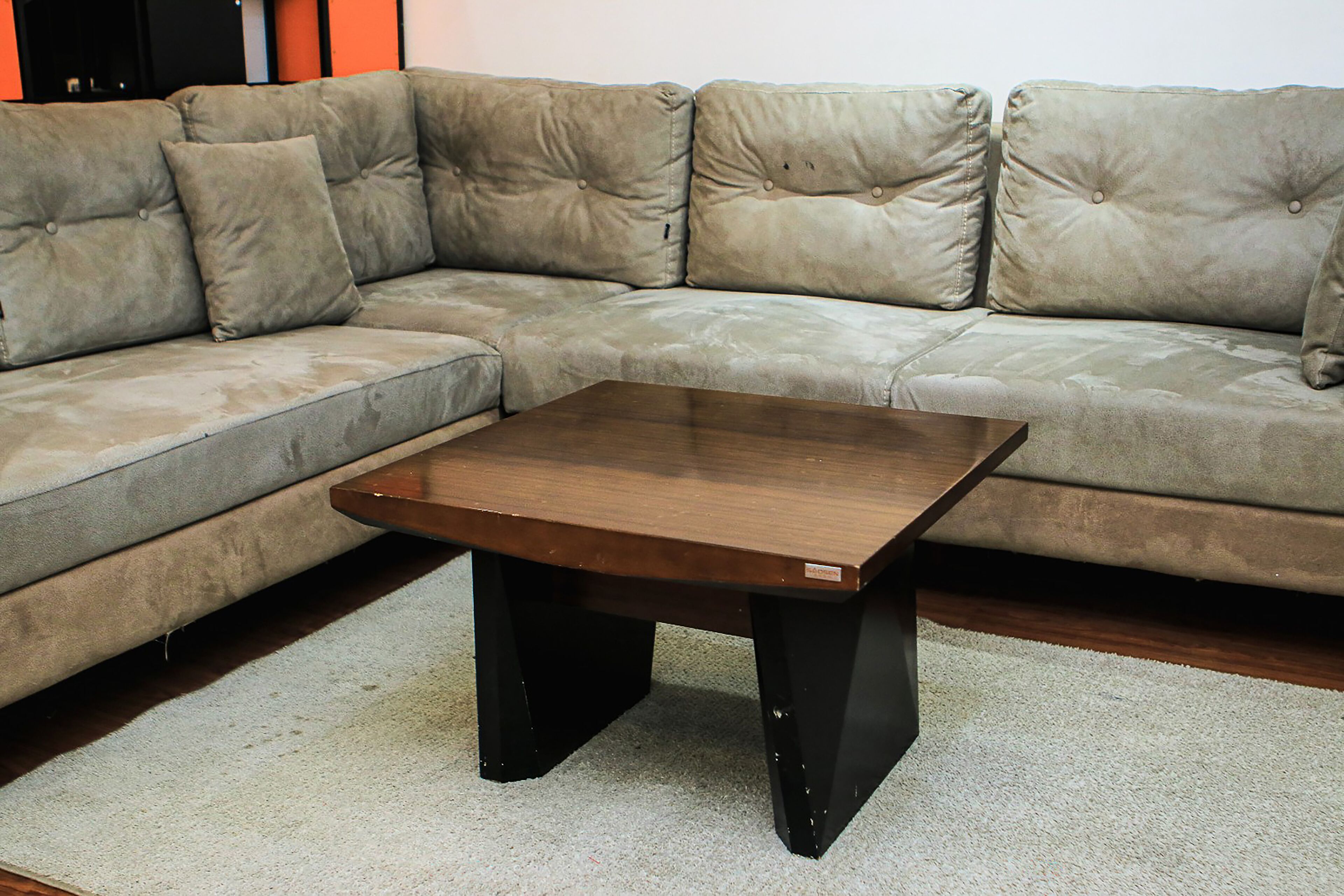 A sectional sofa with a wooden coffee table in front.