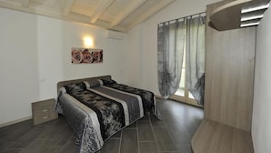 A bedroom with a bed, a wall-mounted artwork, a window with curtains, and a wooden ceiling. - The essence apartments n15 (Malcesine)