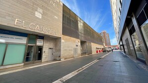 A modern building with the sign "Mercado Municipal El Carmen" and "El Carmen" on the facade. - Estudio con Cama Doble - Picú Home (Málaga)