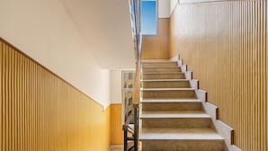 Eine Treppe mit hölzernem Geländer und beigefarbenen Teppichstufen.