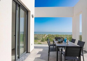 Enjoy ocean views from this sheltered patio with a dining table and comfortable seating for six.