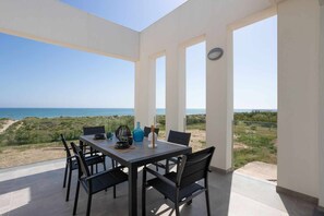 Enjoy ocean views from this outdoor dining area with a table and four chairs.