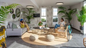 Un salon moderne avec un canapé, des fauteuils, une table basse et des plantes en pot.