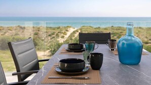 Une table dressée pour le dîner, avec vue sur l’océan.