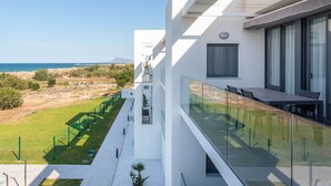 Ein modernes Gebäude mit einem Glasbalkon mit Blick auf eine Küstenlandschaft.