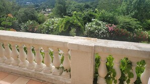 A balcony with a view of a lush green landscape and distant hills. - Mas "Naturelle" Cévennes (Molières-sur-Cèze)