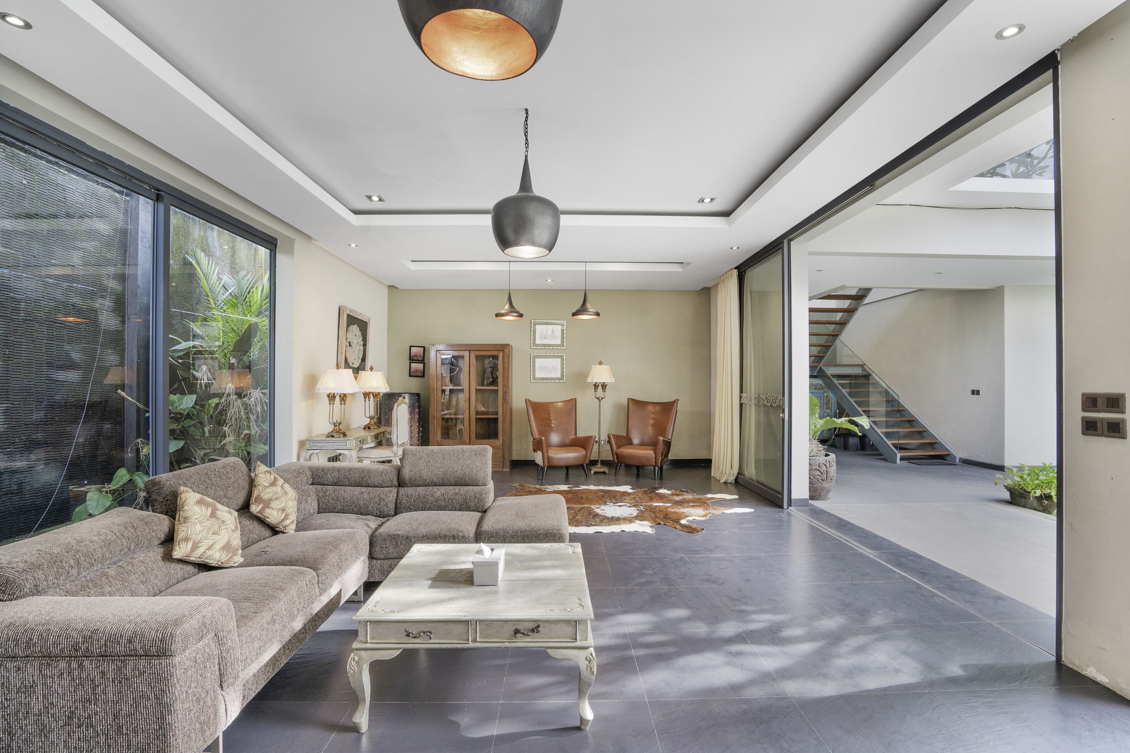 A spacious living area with a sectional sofa, a coffee table, and a large window.