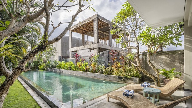 A pool area with lounge chairs and a partially constructed building. - Neo Buana Villa by Betterplace (Canggu)