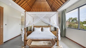 A bedroom with a canopy bed, wooden headboard, bedside tables, and a view of the outside. - Neo Buana Villa by Betterplace (Canggu)