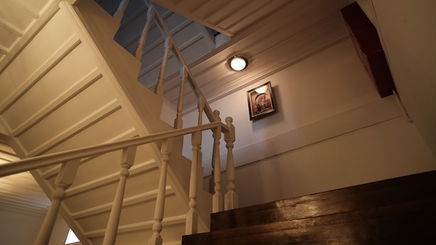 A staircase with white balusters and a wooden handrail leading to a landing. - Mecit Kaptan Konağı (Kastamonu)