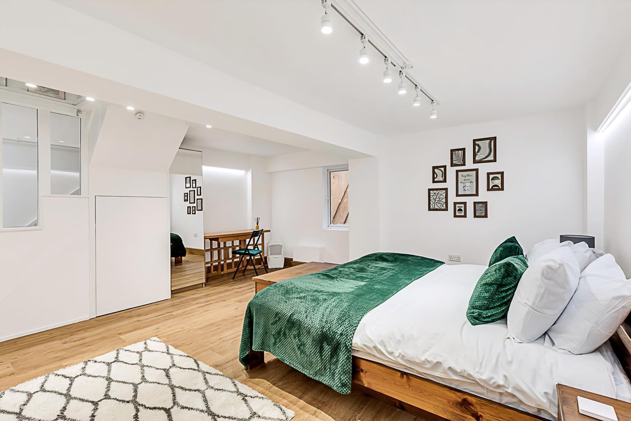 A modern bedroom with a bed, a desk, and a chair.