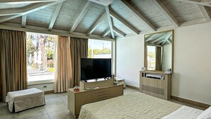 A hotel room with a large bed, a TV, a dresser, and a window with curtains. - Female Resort (San Felice Circeo)
